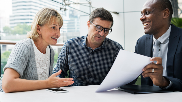 A couple discussing with an investment advisor in an office environment