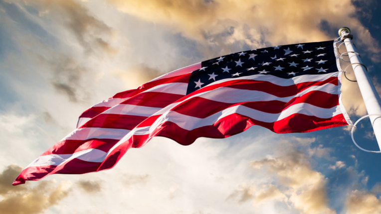 United States flag with stars and stripes blowing in the wind.
