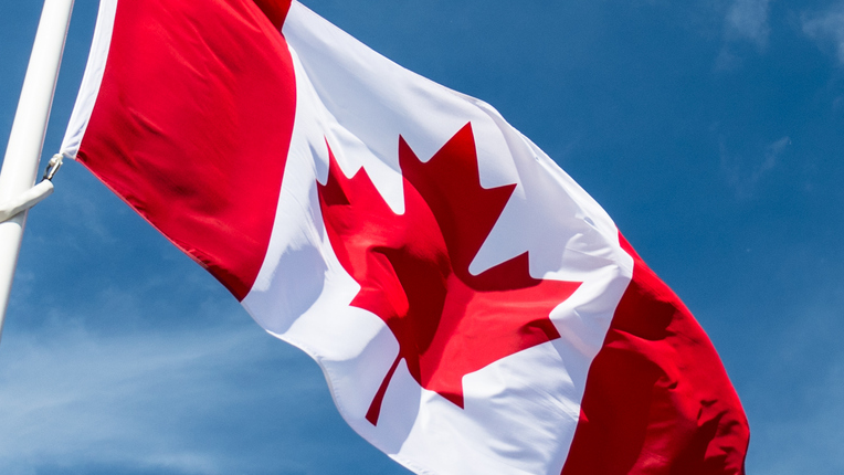Canadian flag in front of blue sky