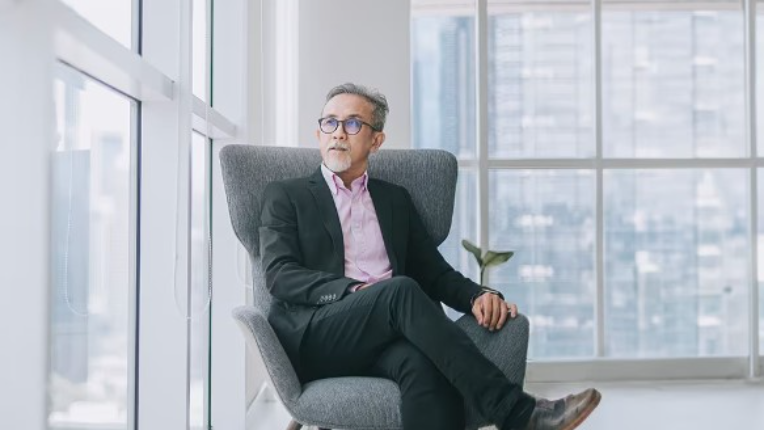 Businessperson sitting in armchair in urban building.