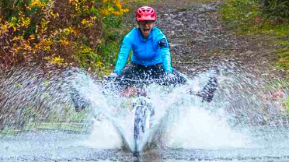 person riding mountain bike through water